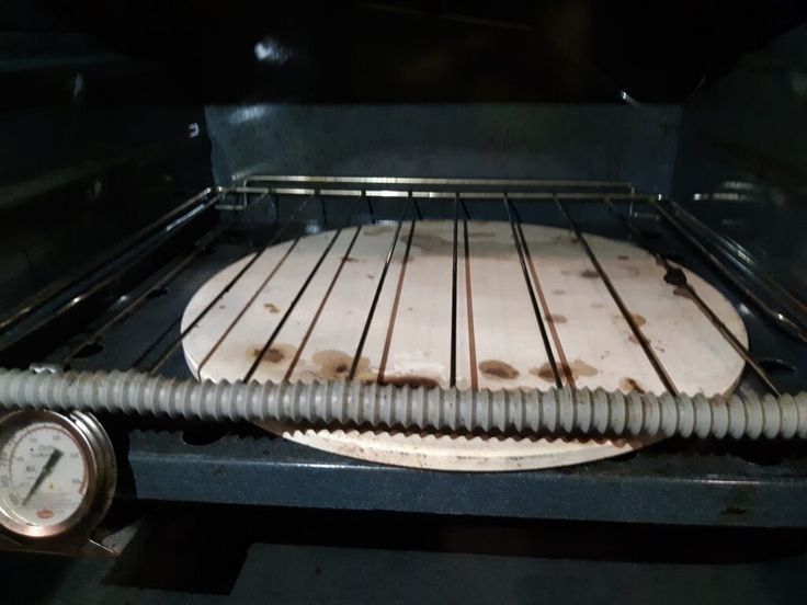 an uncooked pizza sitting in the oven on top of it's rack