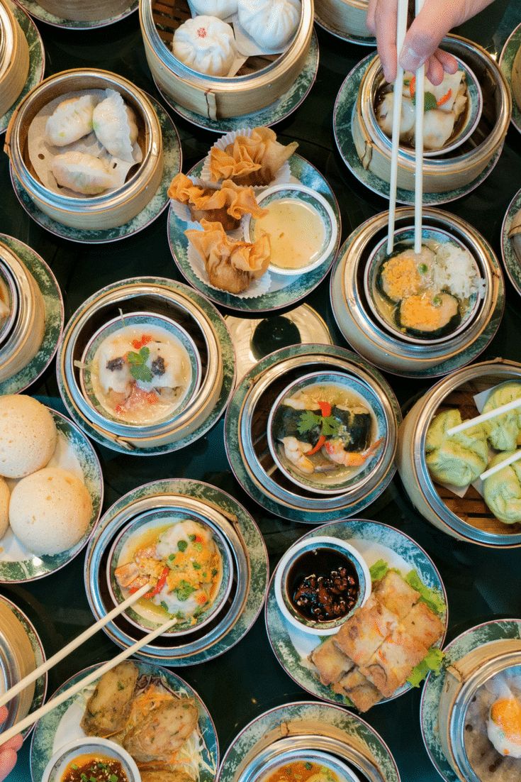 several bowls filled with food and chopsticks on top of a table next to each other