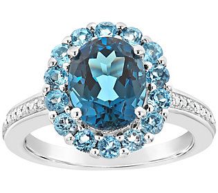 Royal blue. An oval-shaped London blue topaz gemstone is featured in the center of this sterling silver ring and surrounded by a halo of round, lighter blue topaz gemstones. To make this ring more regal, diamonds accent the polished shank and add more sparkle to a smashing design.  For more details on this ring's fit, please refer to the Ring Size Guide above. Blue Topaz Halo Ring For Anniversary, Blue Oval Topaz Ring With Halo Setting, Oval Blue Topaz Ring With Halo Setting, Silver Halo Ring, Blue Topaz Jewelry, Topaz Jewelry, London Blue Topaz Ring, White Diamond Ring, Blue Topaz Stone