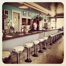 there are many stools at the bar in this restaurant that is empty and ready for customers to use