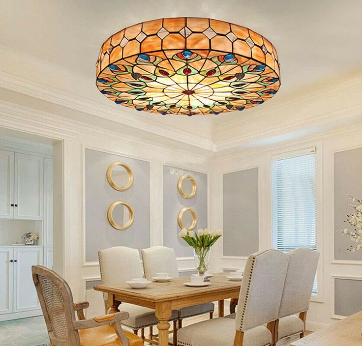 a dining room table with chairs and a chandelier hanging from it's ceiling