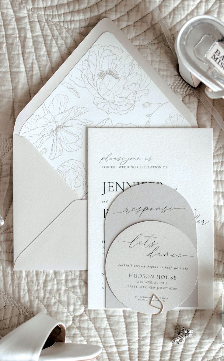 the wedding stationery is laid out on the bed