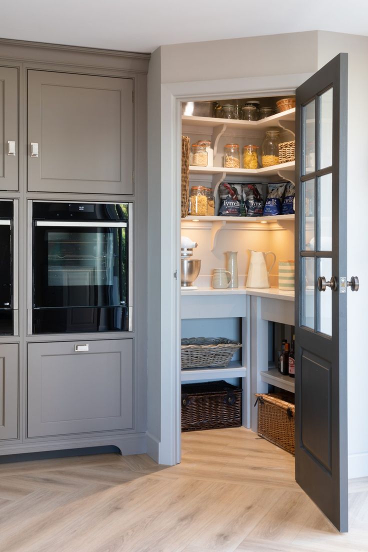 an open door leading into a kitchen with gray cabinets