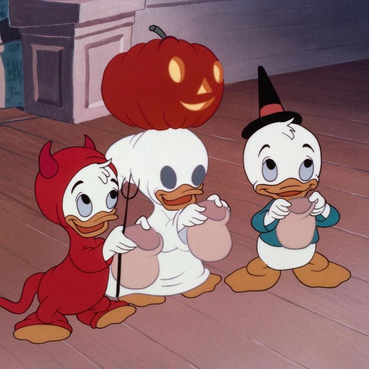 three cartoon characters dressed in costumes standing on a porch with pumpkins and an apple