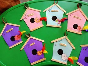 a green table topped with lots of colorful bird houses