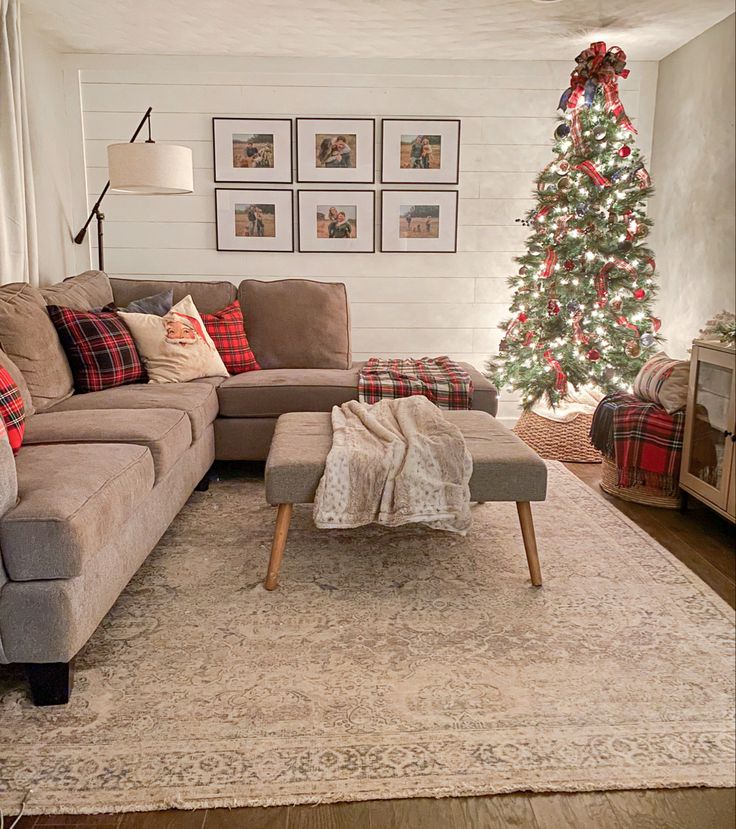 a living room with a christmas tree in the corner and couches on the floor