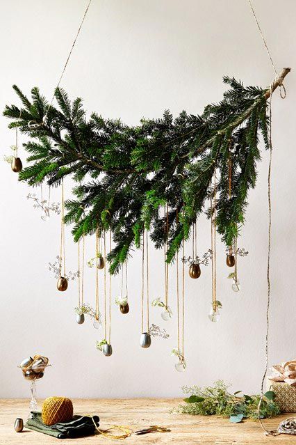 a christmas tree with ornaments hanging from it's branches and other decorations on the table