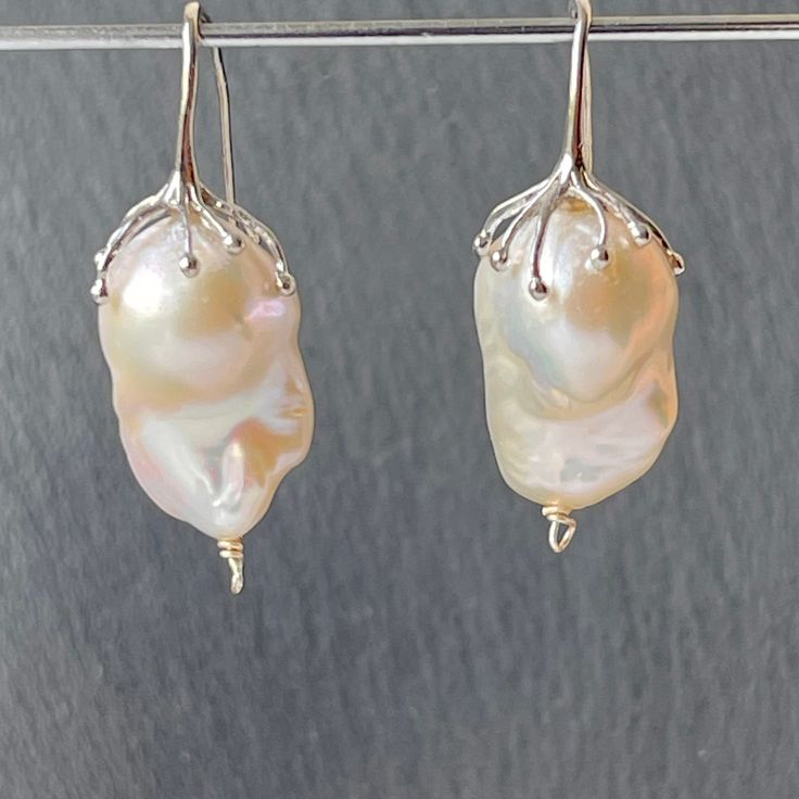 Large freshwater iridescent white baroque pearl drop earrings for women in rhodium plated 925 sterling silver that would make a real statement on your wedding day! With amazingly beautiful lustre and aaa grade, these elegant earrings would make exquisite jewelry gifts for a bride or mother of the bride or groom These high quality cultured pearls come naturally in different shapes but these pairs have been bought specially as a closely matched pair. The natural variations in shape adds to their b Unique White Baroque Pearl Jewelry, Unique Pearl Drop Earrings For Wedding, Unique Wedding Pearl Drop Earrings, Unique Baroque Pearl Drop Jewelry, Handmade Baroque Pearl Jewelry In Pearl White, Elegant Drop Pearl Earrings, Delicate Silver Pear-shaped Jewelry, White Gold Drop Jewelry With Pearl Charm, Elegant Baroque Silver Jewelry