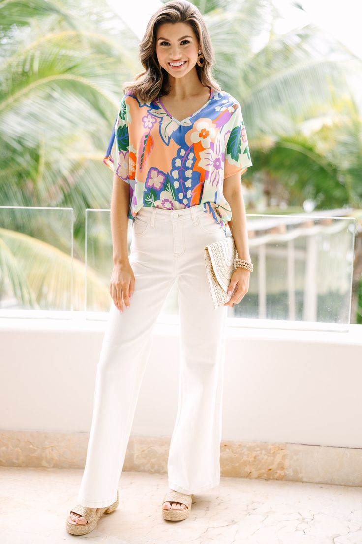 This top is so cute and comfy! That print is so pretty and those colors are so fun. This light blouse is going to look great with white jeans or shorts this spring and summer! V-neckline Short sleeves Floral print No stretch Savannah is wearing the small. Chic White V-neck Top For Day Out, Casual Short Sleeve V-neck Top For Brunch, Summer Cotton V-neck Top For Day Out, Summer Rayon V-neck Tops, White V-neck Top For Summer Vacation, V-neck Top With Tropical Print For Brunch, Trendy V-neck Blouse With Vibrant Print, Summer V-neck Blouse With Tropical Print, Cotton V-neck Top For Spring Day Out