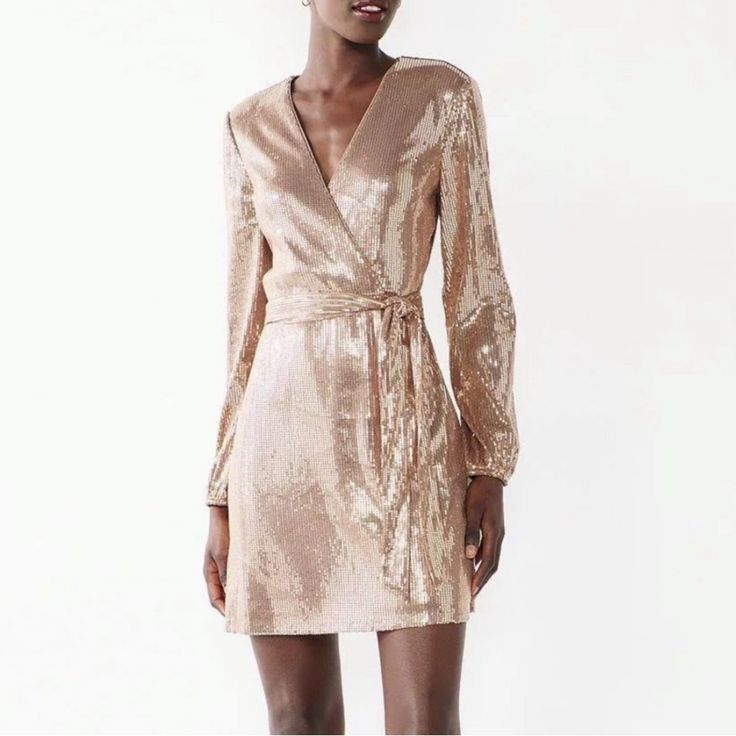 Nine West & Carlos Santana Collaboration Has Resulted In This Stunning Champagne Sequin Mini Cocktail Dress. The Design Is Simple But Makes A Huge Fashion Statement. Turn Heads In This Gorgeous Dress. Get It For The Lowest Price On The Net And Slay Dressy Gold Mini Length Dress, Chic Gold Mini Dress With Long Sleeves, Gold Long Sleeve Mini Dress For Holiday Party, Gold Long Sleeve Mini Dress For Spring, Gold V-neck Mini Dress For Fall, Sequin Dresses For Brunch And Party Season, Chic Fitted Wrap Dress For Party, Sequin Dresses For Party Season, V-neck Mini Dress For Spring Holiday Party