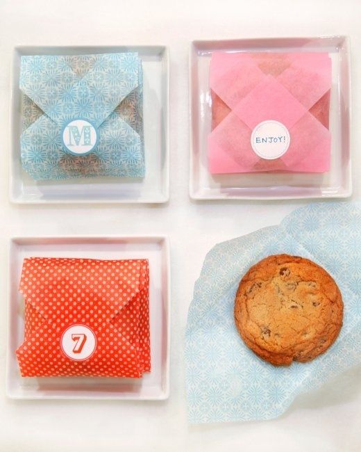 four plastic trays with cookies and envelopes on them