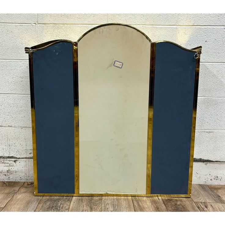 an art deco style mirror with blue panels and gold trimmings on the sides