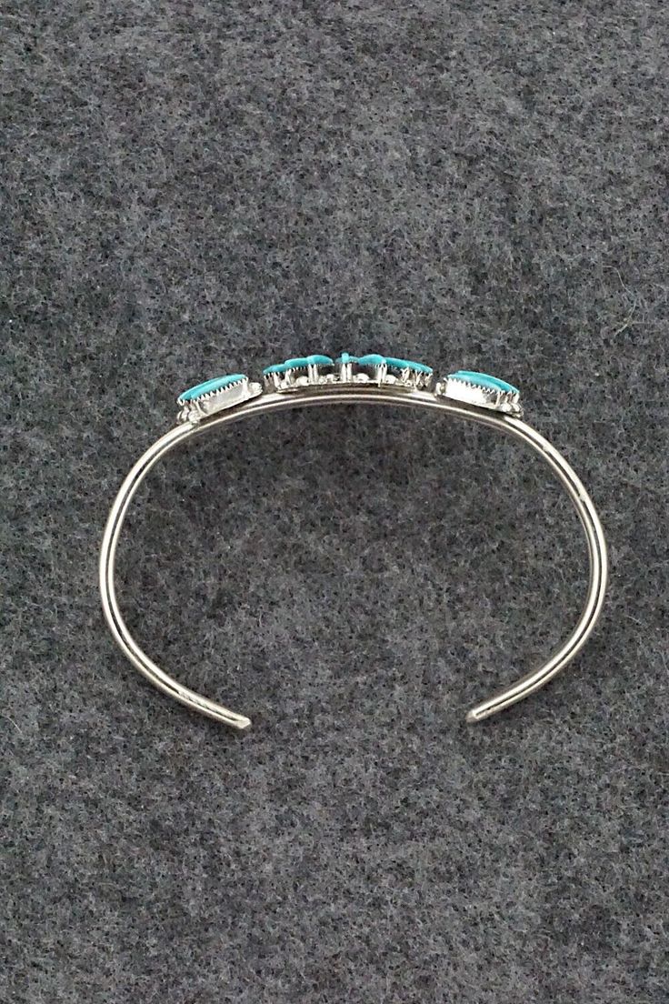 This finely crafted turquoise and sterling silver bracelet was made by Zuni silversmith Carla Laconsello. The back is signed.Size: 5 1/8" (will fit up to a 6 1/8" wrist)Gap: 1"Length: 1 1/4"Free shipping on all orders! We ship with USPS and always include tracking. All orders ship within a day of payment.Returns are accepted up to 30 days after you receive your order. Just send us a message. Our shop offers cash back or store credit. The item must be returned in new condition. Turquoise Sterling Silver Cuff Bracelet With Polished Finish, Turquoise Sterling Silver Cuff Bracelet With Inlay, Sterling Silver Turquoise Cuff Bracelet With Inlay, Elegant Turquoise Bracelet With Inlay, Turquoise Bangle For Formal Occasions, Formal Turquoise Sterling Silver Bracelets, Elegant Turquoise Inlay Bracelet, Formal Turquoise Bangle Jewelry, Round Turquoise Sterling Silver Cuff Bracelet