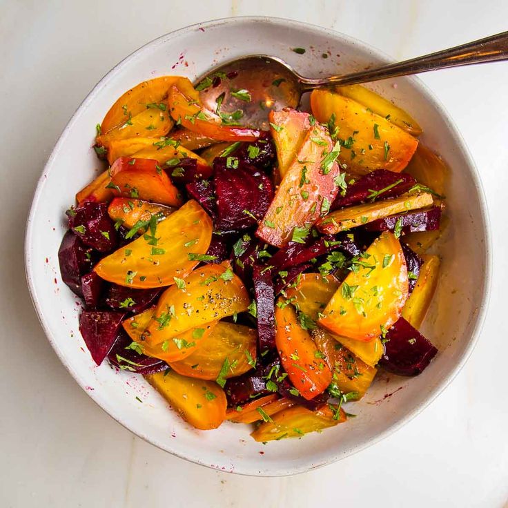 a white bowl filled with sliced up vegetables and garnished with parsley on top