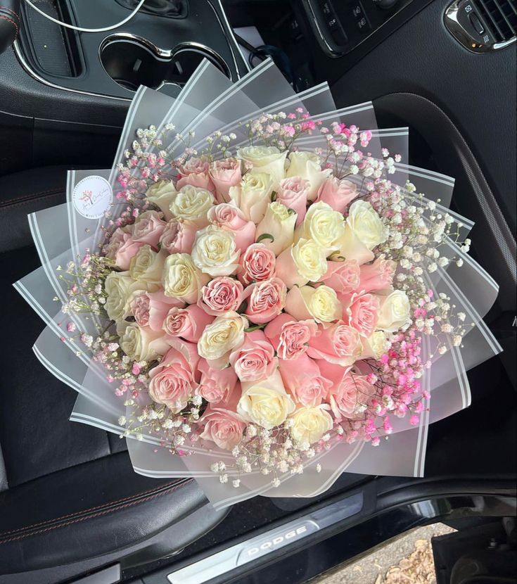 a bouquet of flowers sitting in the center of a car seat with pearls on it