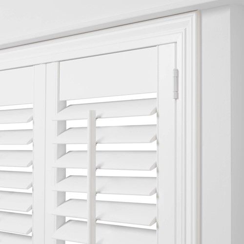 the shutters are closed to let in light on the room's white walls