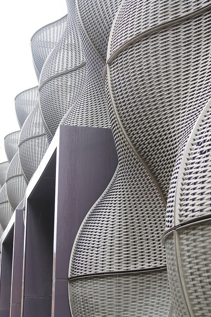 the side of a building that is made out of wicker and has curved sides