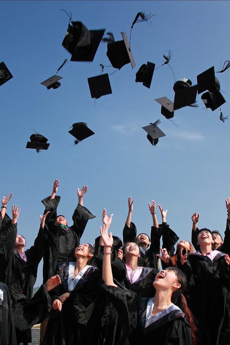 a group of graduates throwing their caps in the air