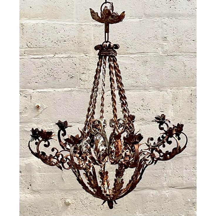 a chandelier hanging from the ceiling in front of a white brick wall