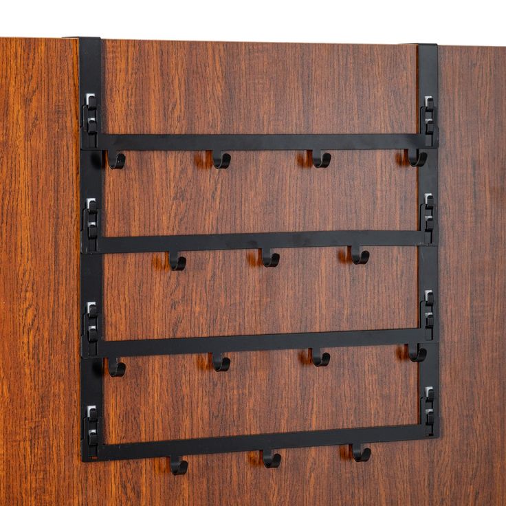 a wall mounted coat rack with five hooks and four bars on the bottom half of it