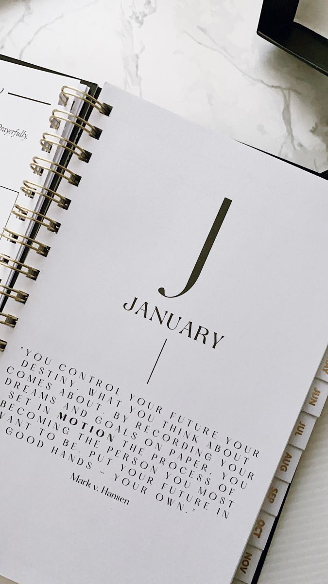 a spiral notebook with the word j on it next to a pen and eyeglasses