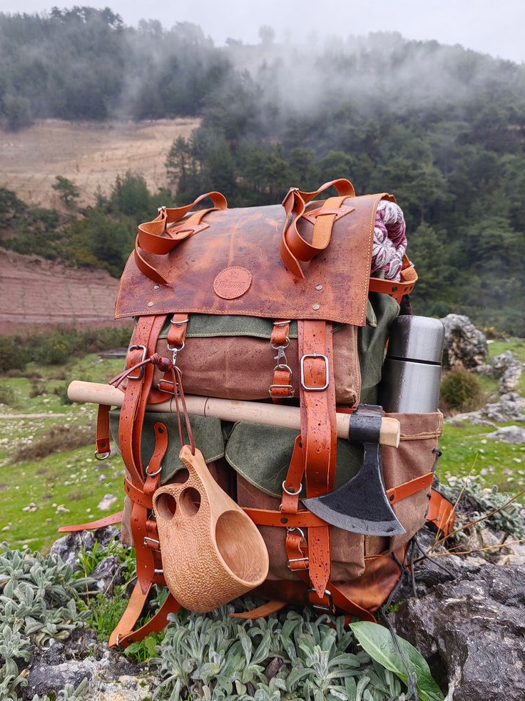 an old backpack is piled on top of some rocks with gardening utensils attached to it