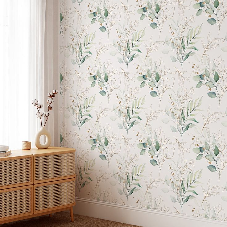 a wallpapered room with flowers and plants on the wall next to a dresser