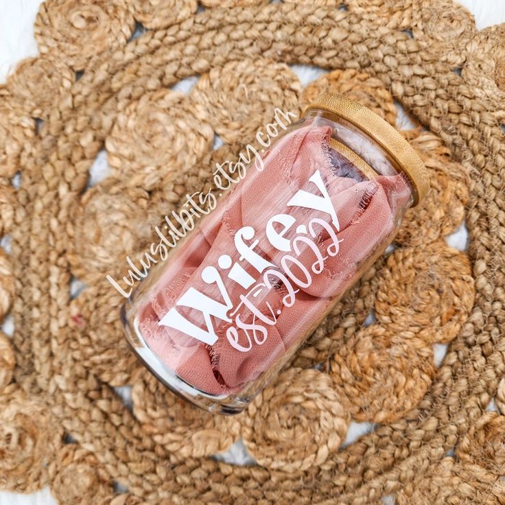 a jar filled with pink liquid sitting on top of a rug