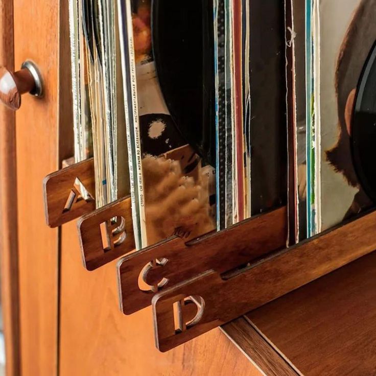 a close up of a mirror on a wooden door with records in the reflection and an old record player next to it