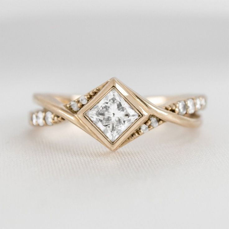 a gold ring with a princess cut diamond in the center