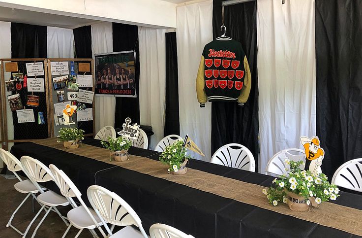 tables and chairs are set up in front of a black backdrop with white drapes