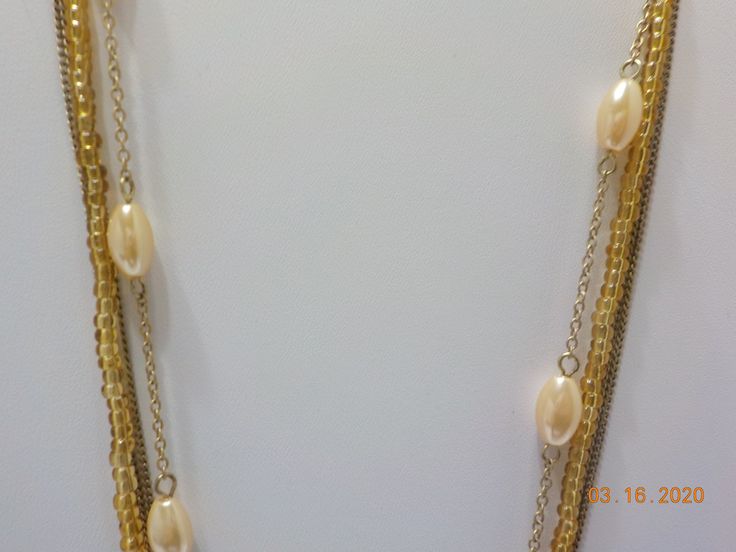 "Vintage gold tone triple strand choker necklace. One strand with pale faux pearls, two srands of gold tone chains, & the other strand is tiny gold tone plastic beads. 2\" extension chain. Lobster claw fastener. Classic!" Gold Multi-strand Pearl Necklace With Adjustable Chain, Gold Multi-strand Pearl Necklace, Gold Multi-strand Beaded Chain Necklace, Gold Pearl Beaded Chain Layered Necklace, Gold Multi-strand Layered Necklace With Beads, Gold Pearl Layered Necklace With Beaded Chain, Gold Layered Necklace With Pearl Chain For Party, Gold Multi-strand Pearl Layered Necklace, Gold Pearl Multi-strand Layered Necklace