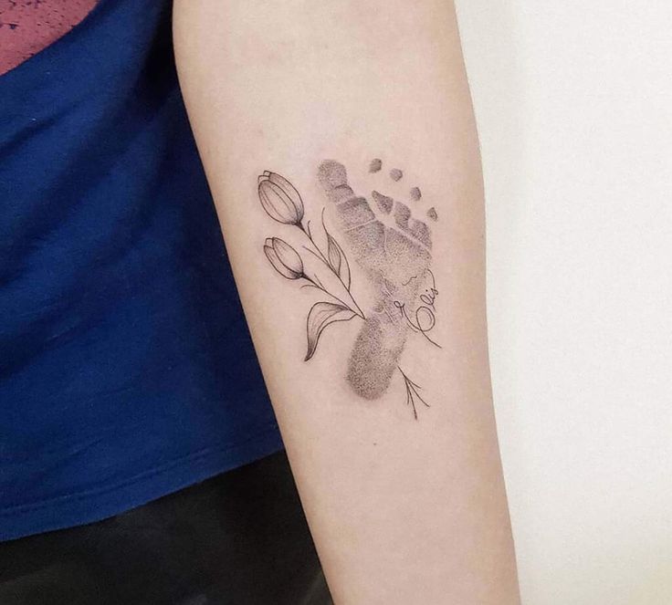 a woman's arm with a tattoo on it that has flowers growing out of it