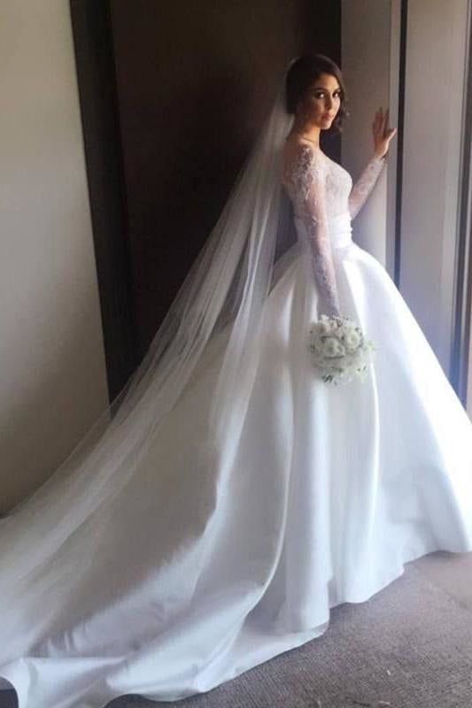 a woman in a white wedding dress standing next to a door wearing a long veil