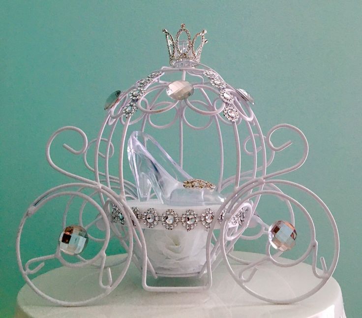 a white birdcage filled with shoes and jewelry on top of a cake stand