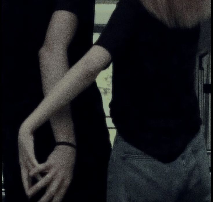 two people standing next to each other with their hands together