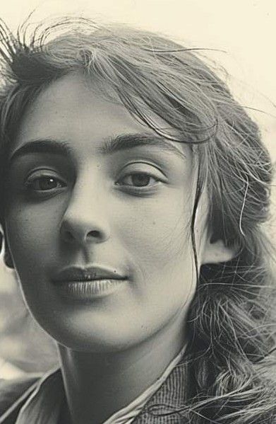 black and white photograph of a woman with hair blowing in the wind, looking off to the side