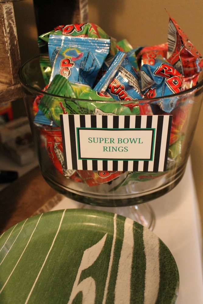 a bowl full of candy sitting on top of a table next to a plate with a name tag