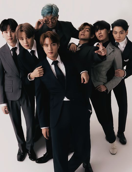 a group of young men in suits and ties posing for the camera with their arms around each other