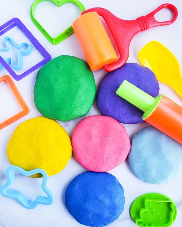 colorful play dough and toys on a white surface