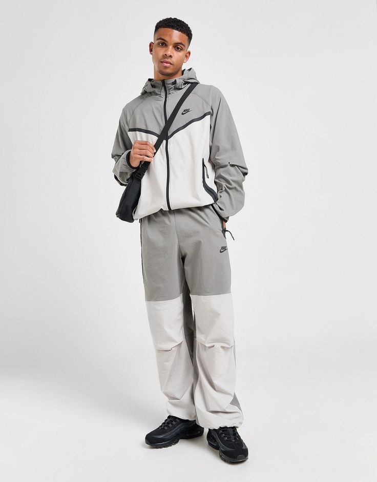 Street-ready style lands from the Swoosh with these men's Tech Woven Oversized Track Pants from Nike. In a Flat Pewter and Light Iron Ore colour block design, these roomy pants are cut from lightweight stretch-woven fabric that helps wick sweat from the skin. They feature articulated knees for extra movement and an elastic waistband with a bungee drawcord to secure them in place. With different sized Tech tape pockets for your essentials, they're finsihed off with the signature Nike Futura logo. Machine washable. | Our model is 6'1" with a 39" chest and wears a size medium. Grey Nike Tech, Oversized Track Pants, Gym Tights, Retro Football Shirts, Iron Ore, Dodgers Baseball, Adidas Originals Superstar, Football Training, Gym Tops