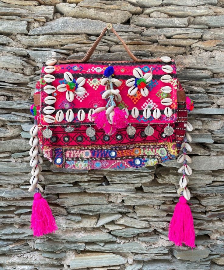 About bag  Indo-gypsy fusion, everyday use hand bag made from Banjara fabrics sourced from Vintage tribal costumes of regions of Rajastan and Gujarat. These are embellished with light catching coins, and intricate bead work tassels. Size - length 15 inches/ width 21 inches Company details:  Company name: Houseoftextile  Contact number: +919784447473  Email id: houseoftextile77@gmail.com  Shipping & custom : Delivery through one of the finest service providers : Skyway, Fedex, UPS  And DHL. Any l Handmade Bohemian Bags For Festivals, Bohemian Festival Shoulder Bag, Bohemian Pink Satchel Bag, Navratri Bohemian Potli Bag With Handwork, Bohemian Bag With Handwork For Festival, Bohemian Multicolor Embroidered Potli Bag For Festivals, Bohemian Bags With Handwork For Festivals, Bohemian Rectangular Potli Bag With Handwork, Bohemian Rectangular Potli Bag For Festivals