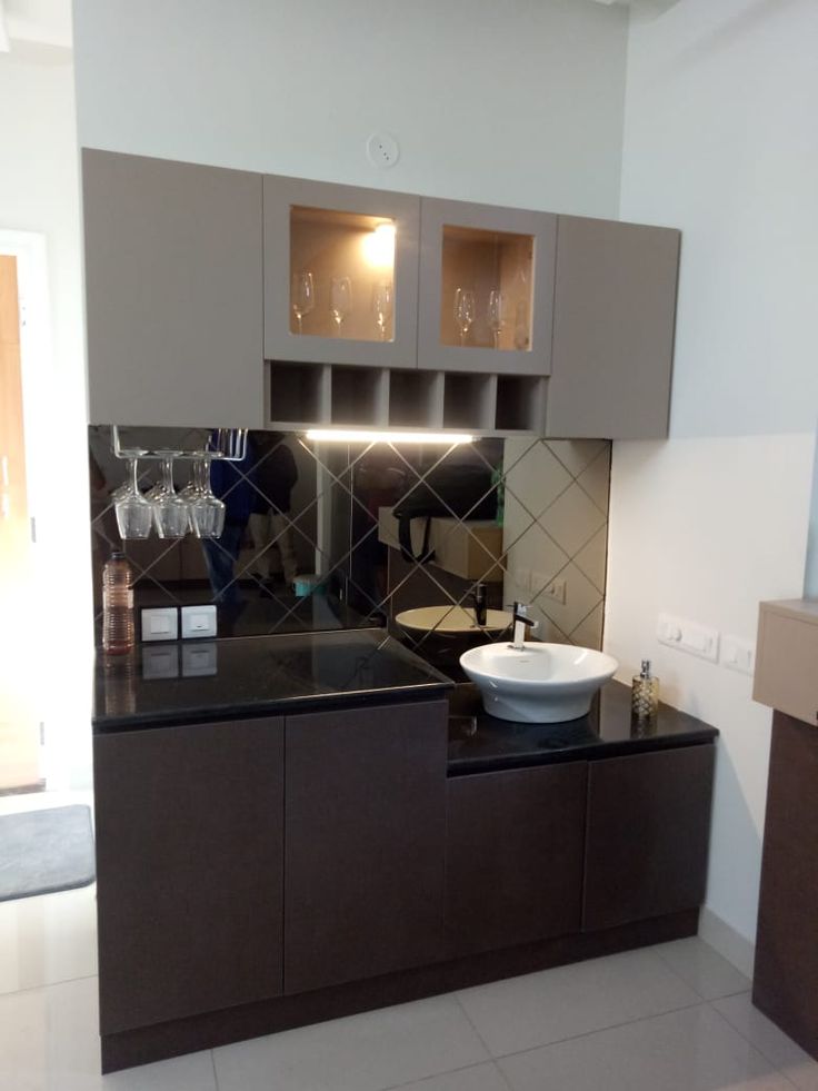 a modern kitchen with black counter tops and brown cabinets