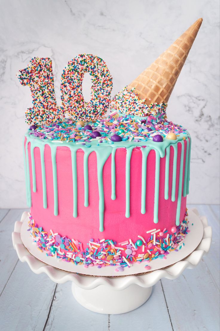 a birthday cake with sprinkles and ice cream on top that has the number ten on it