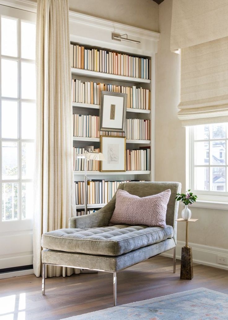 a chair in front of a book shelf filled with books