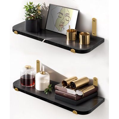 two black shelves with gold handles holding various items