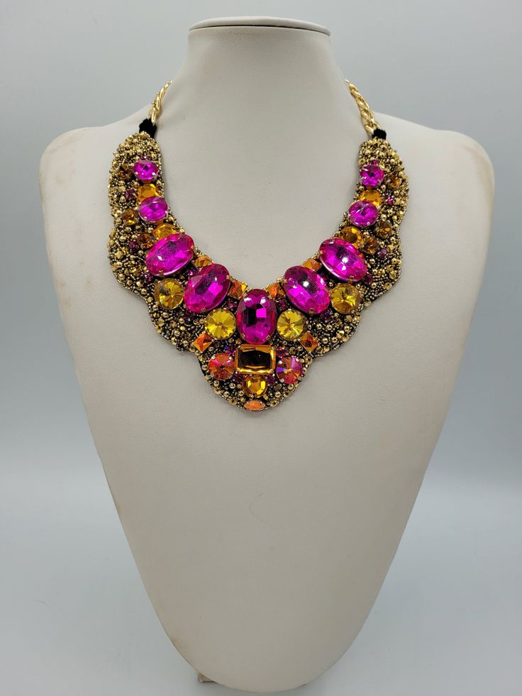 Each piece of our statement necklaces is handmade and one of a kind made in Italy. Our creations is made of high quality materials such as crystals and rhinestones. Each embroidered material is carefully hand sewn. Very glamorous and stylish. Perfect gift to someone you like. Materials Strass stone and Rhinestone in Fuchsia, Gold, Astral Pink and Light Topaz color in different dimension.  Black satin fabric backing. Aluminium chain with lobster closure. Measurements Weight approximate 200 grams. Chain lenght 25 cm - 9.84 in Circumference approximate 63 cm - 24.80 in Feel free to contact us if you have any question. Thank you so much for looking at our shop and our articles each of them, single piece. Crystal Jeweled Necklaces For Celebration, Multicolor Jeweled Beaded Necklace For Party, Party Crystal Pendant Necklace With Rhinestones, Crystal Pendant Necklace For Party, Gold Necklaces With Stones For Party, Costume Jewelry Rhinestone Pendant Necklace For Party, Pink Rhinestone Jeweled Necklace For Parties, Pink Jeweled Rhinestone Necklace For Party, Glamorous Sparkling Stone Necklaces For Celebration