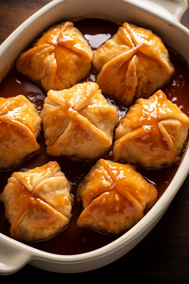 some food is in a white dish on a wooden table and it looks like they have wontons