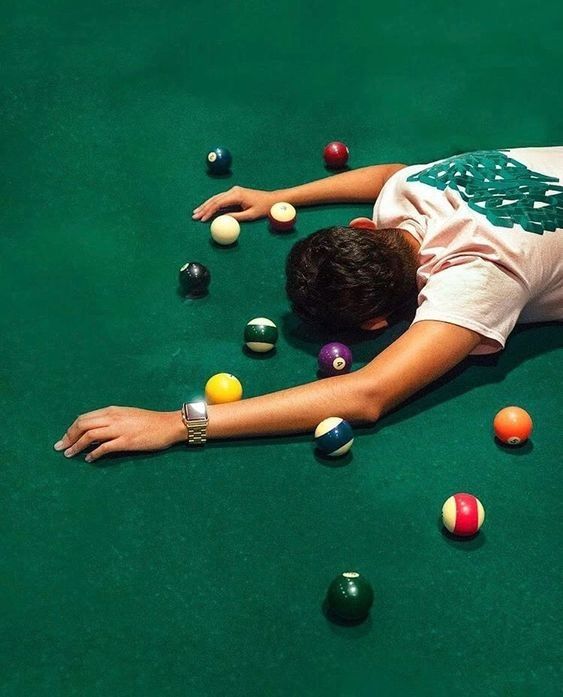 a man laying on the ground with balls in front of him