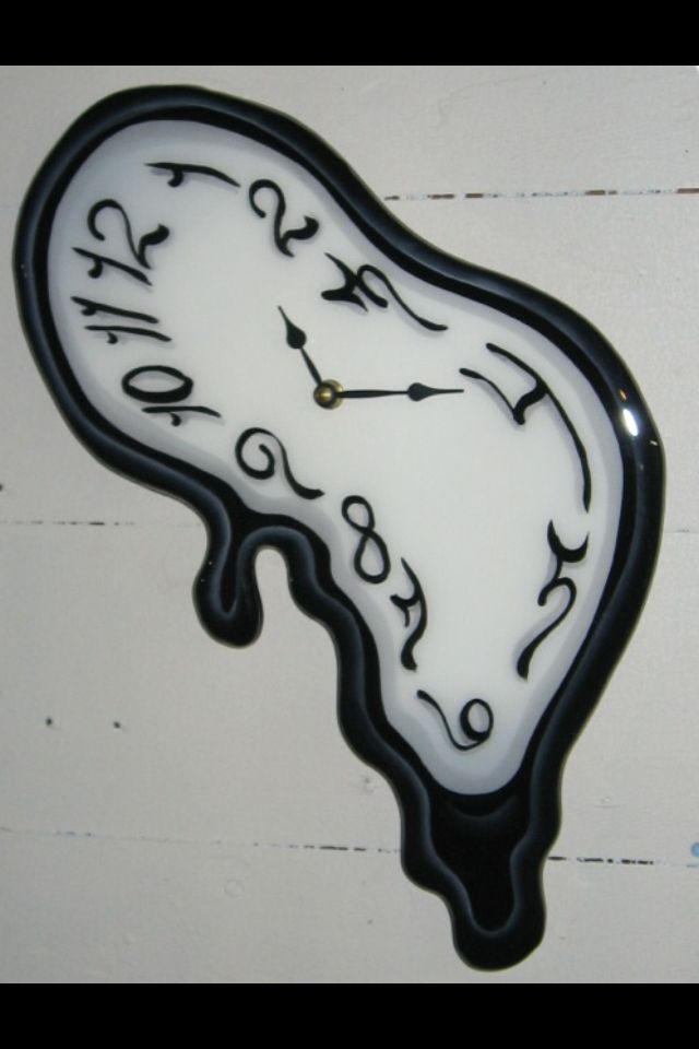 a black and white clock with writing on it's face is hanging from the wall